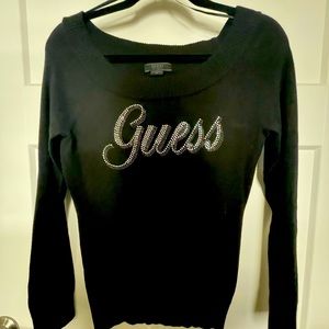 Black Guess off the shoulder sweater with rhinestone accents reading Guess
